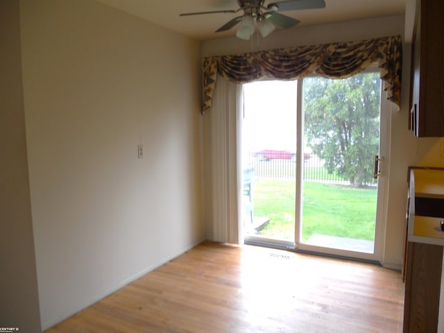unfurnished dining area featuring a ceiling fan and light wood-style floors