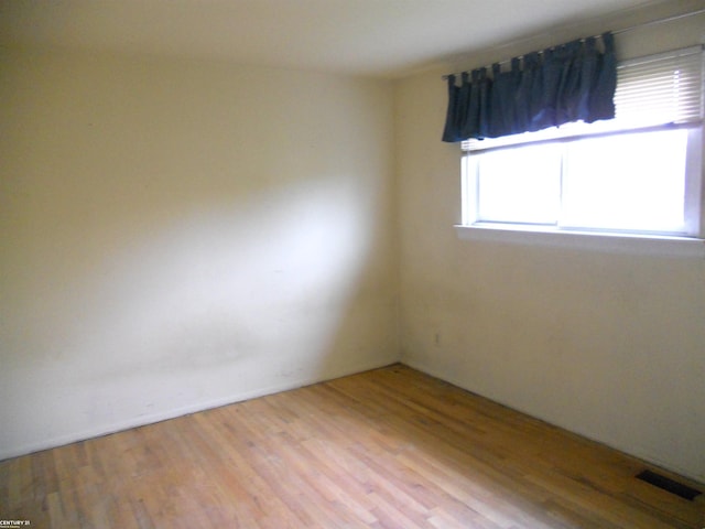 empty room featuring visible vents and wood finished floors