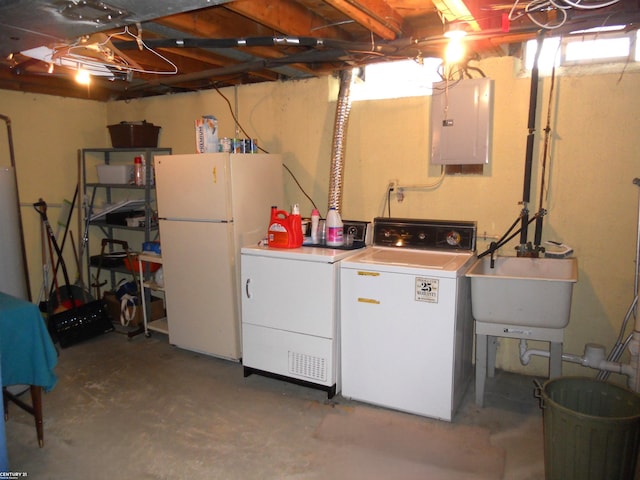 washroom featuring laundry area, washing machine and dryer, a sink, and electric panel