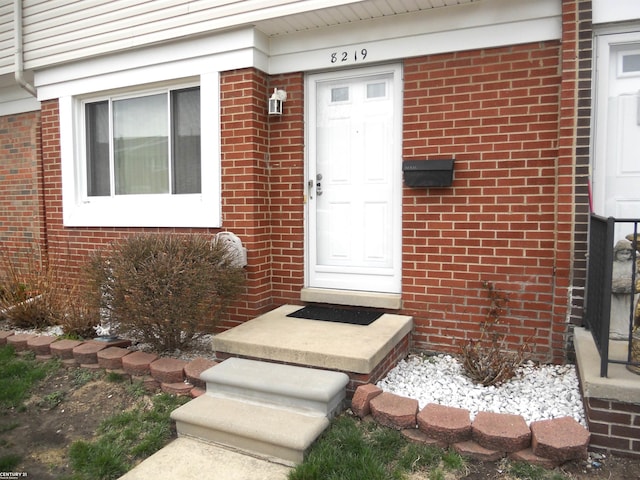 doorway to property featuring brick siding