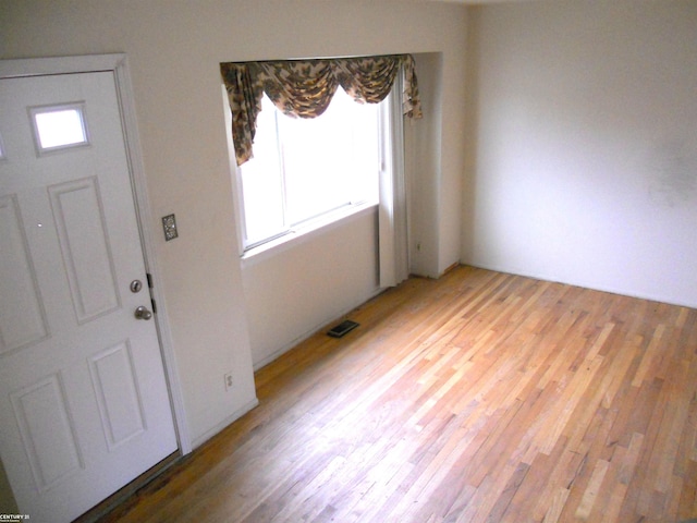 foyer entrance with visible vents and light wood-type flooring