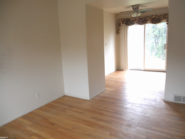 spare room featuring a ceiling fan, wood finished floors, and visible vents