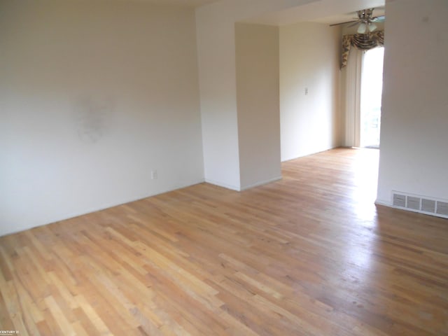 spare room with ceiling fan, visible vents, and light wood-style flooring