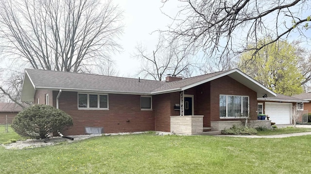 single story home with an attached garage, a chimney, a front lawn, and brick siding