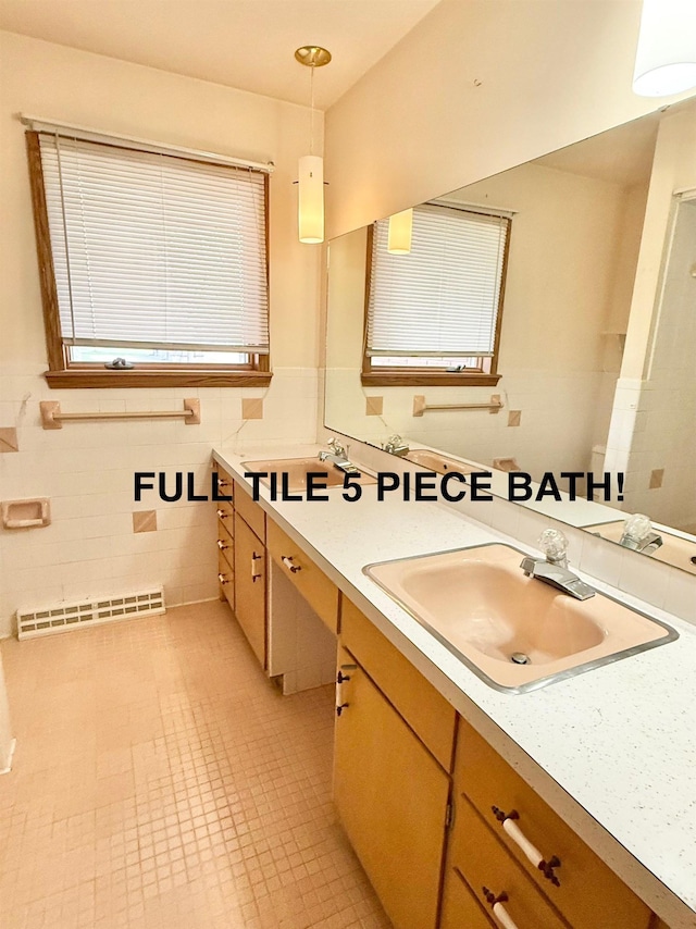 bathroom featuring vanity, a wainscoted wall, tile walls, and visible vents