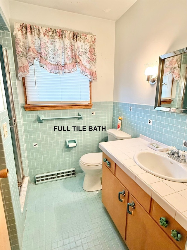 bathroom with tile patterned flooring, vanity, toilet, tile walls, and a shower stall