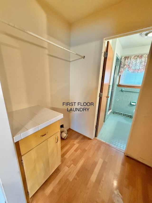 interior space featuring baseboard heating and light wood-style floors