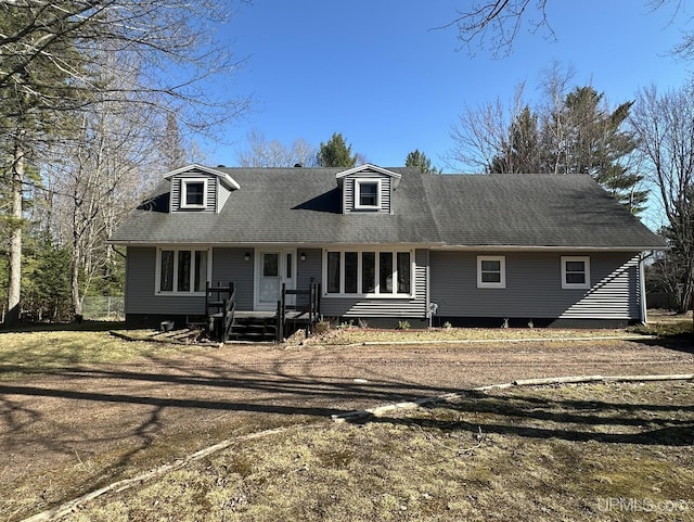new england style home with roof with shingles