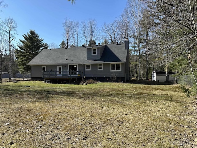 back of property featuring a lawn, a wooden deck, and fence