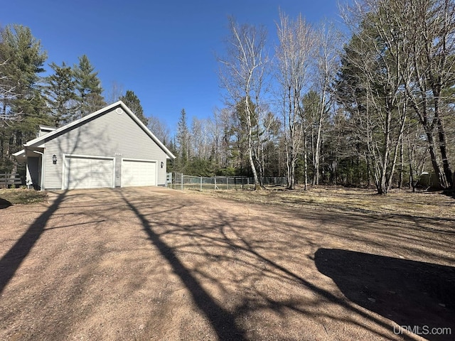 view of yard featuring fence and a garage