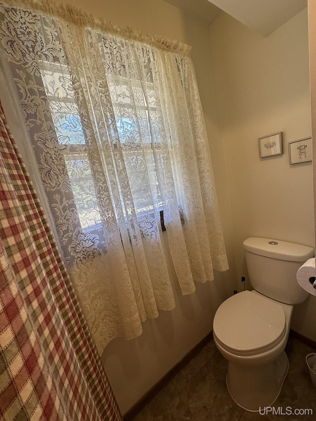 bathroom with baseboards and toilet