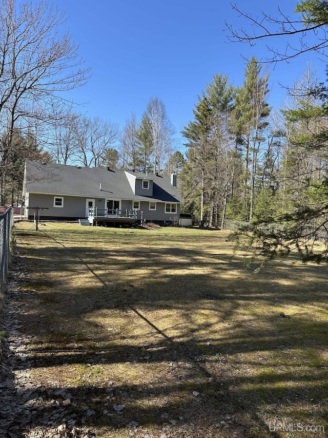 back of house with a yard, a deck, and fence