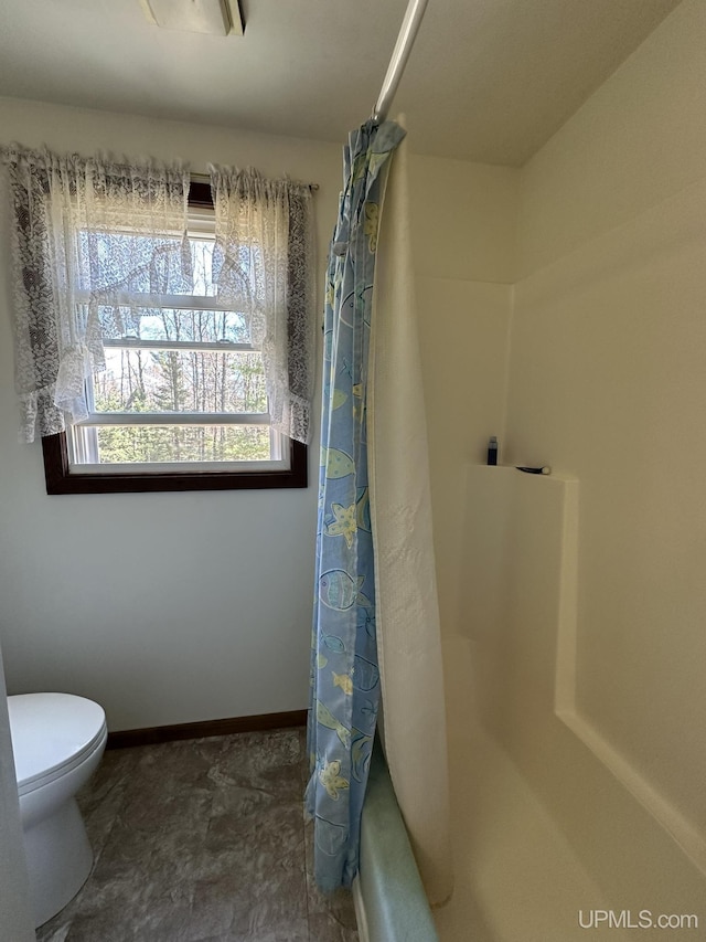 full bathroom with a shower with curtain and toilet