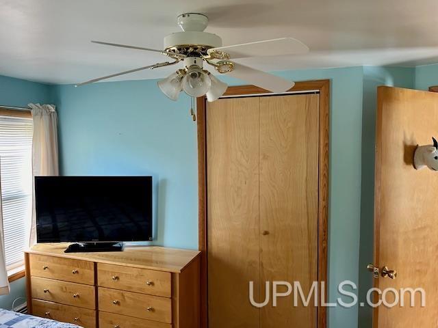 bedroom with ceiling fan and multiple windows