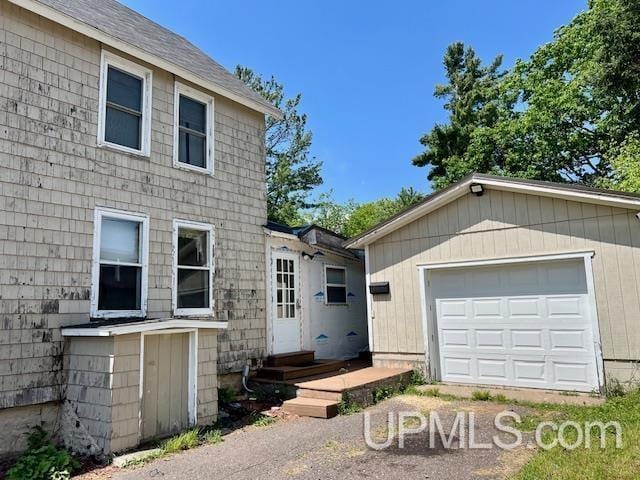 exterior space with a detached garage, an outdoor structure, and entry steps