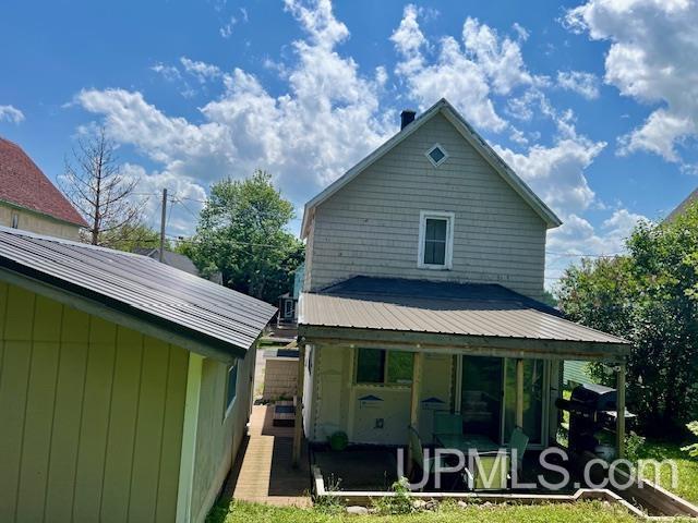 back of house featuring metal roof