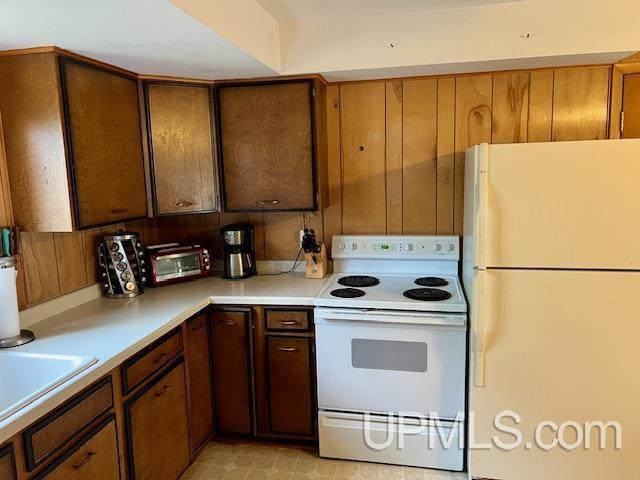 kitchen with light countertops, a sink, a toaster, and white appliances