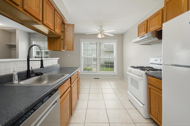 kitchen with ceiling fan, dark countertops, a sink, white appliances, and under cabinet range hood