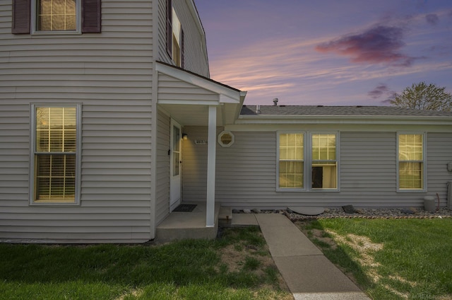 property entrance with a lawn