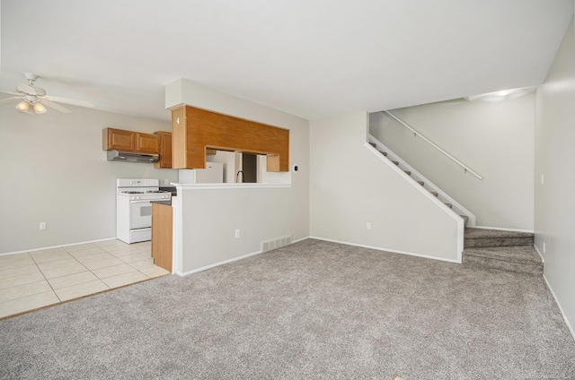unfurnished living room with visible vents, stairs, ceiling fan, and light carpet