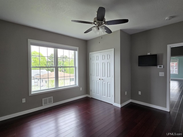 1812 Lake Shore Dr, Escanaba, MI 49829 - unfurnished bedroom featuring dark wood finished floors, baseboards, a closet, and ceiling fan