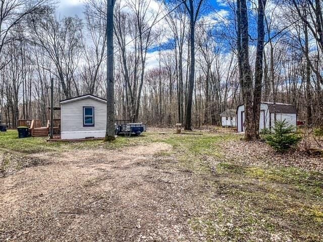 view of yard featuring a storage unit and an outbuilding