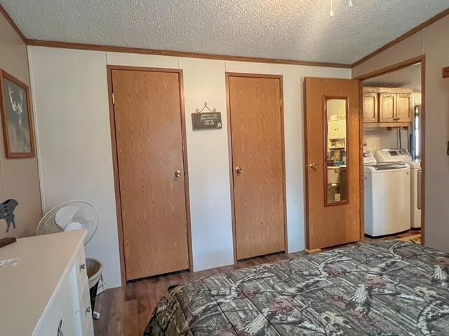 bedroom featuring ornamental molding, a textured ceiling, and washer and dryer