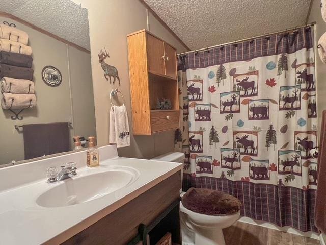 full bath with vanity, a textured ceiling, a shower with shower curtain, and toilet