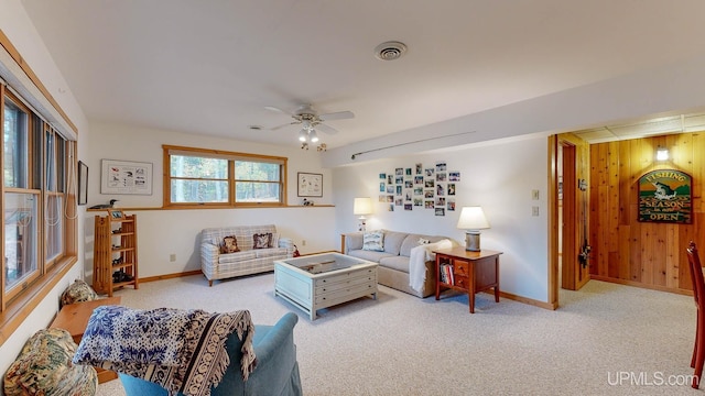 living area featuring carpet, baseboards, a ceiling fan, and visible vents