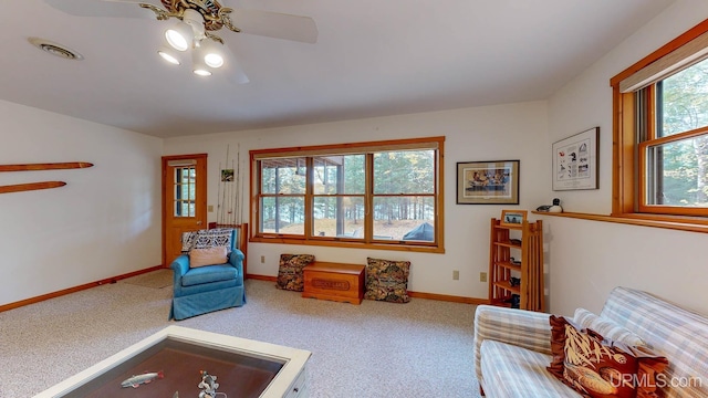 living area featuring ceiling fan, carpet flooring, baseboards, and visible vents