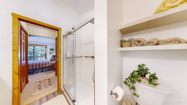 ensuite bathroom featuring connected bathroom, toilet, and a stall shower