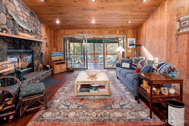 living area with recessed lighting, wooden ceiling, wood-type flooring, wooden walls, and a fireplace