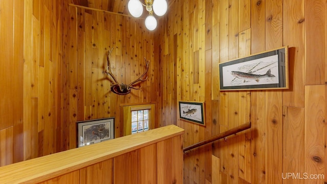 stairway featuring wood walls and ceiling fan