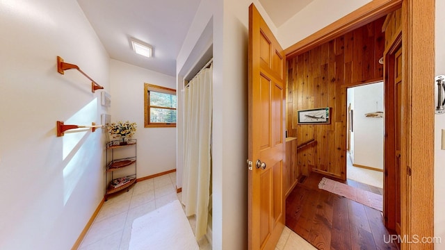 corridor featuring light wood-style floors and baseboards