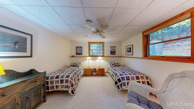 bedroom featuring carpet flooring, a ceiling fan, a drop ceiling, and visible vents