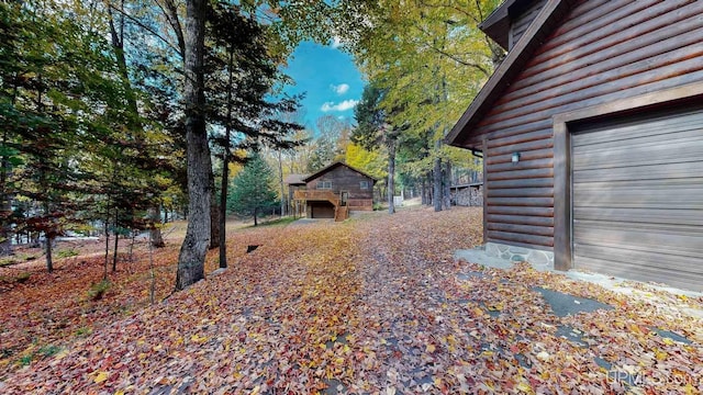 view of side of property featuring log veneer siding and a garage