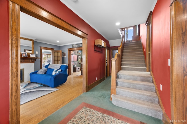 stairway featuring baseboards, recessed lighting, crown molding, and wood finished floors
