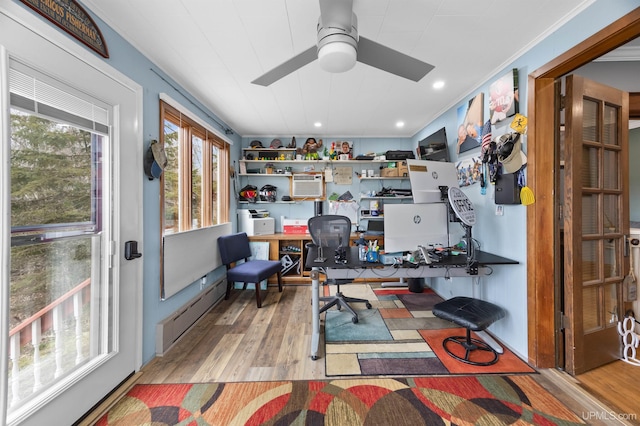office area with ornamental molding, a wall unit AC, a ceiling fan, and wood finished floors