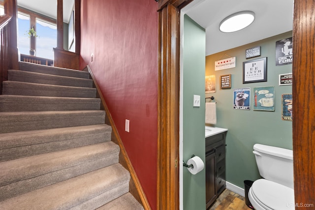 stairs featuring wood finished floors and baseboards