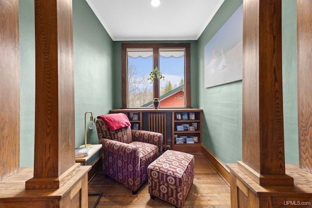 living area featuring crown molding, wood finished floors, and baseboards