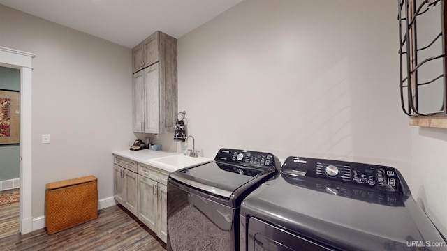 N9006 Sand River Rd, Deerton, MI 49822 - laundry area featuring washing machine and dryer, baseboards, dark wood finished floors, a sink, and cabinet space