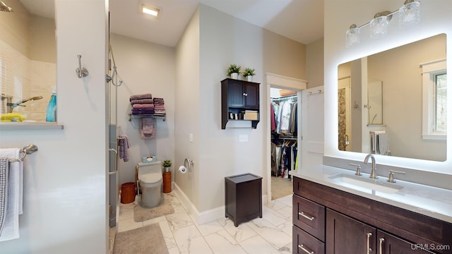 N9006 Sand River Rd, Deerton, MI 49822 - bathroom featuring toilet, marble finish floor, baseboards, vanity, and a walk in closet