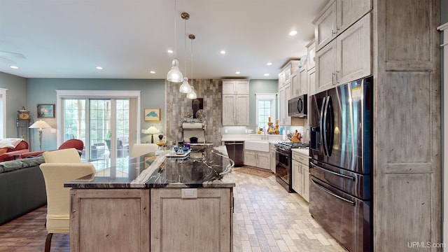 N9006 Sand River Rd, Deerton, MI 49822 - kitchen featuring recessed lighting, black gas range, open floor plan, a kitchen island, and stainless steel fridge with ice dispenser