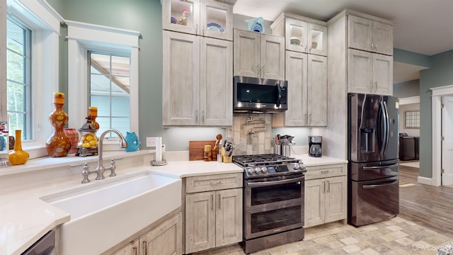 N9006 Sand River Rd, Deerton, MI 49822 - kitchen featuring light countertops, appliances with stainless steel finishes, glass insert cabinets, and a sink