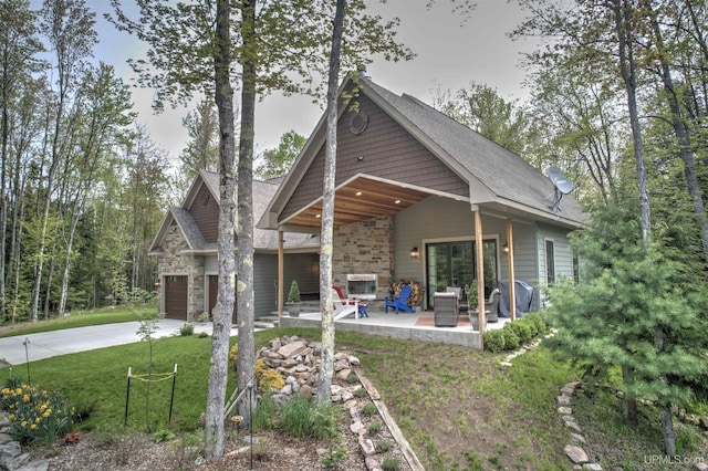 N9006 Sand River Rd, Deerton, MI 49822 - exterior space featuring a patio area, a front lawn, stone siding, and driveway
