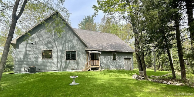 N9006 Sand River Rd, Deerton, MI 49822 - rear view of house with a lawn, central AC, and roof with shingles