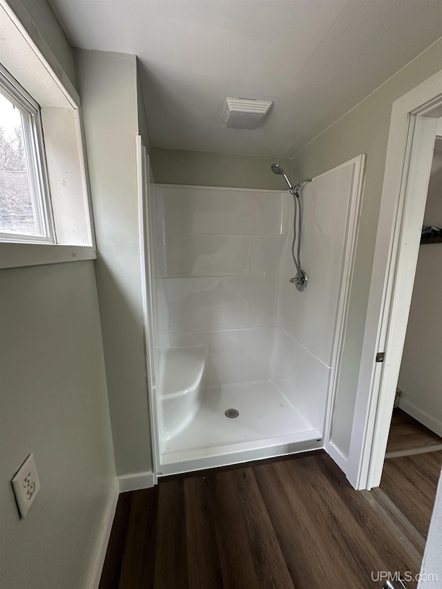 bathroom with baseboards, walk in shower, visible vents, and wood finished floors