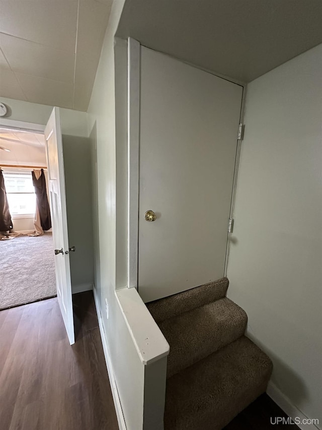 stairway featuring baseboards and wood finished floors