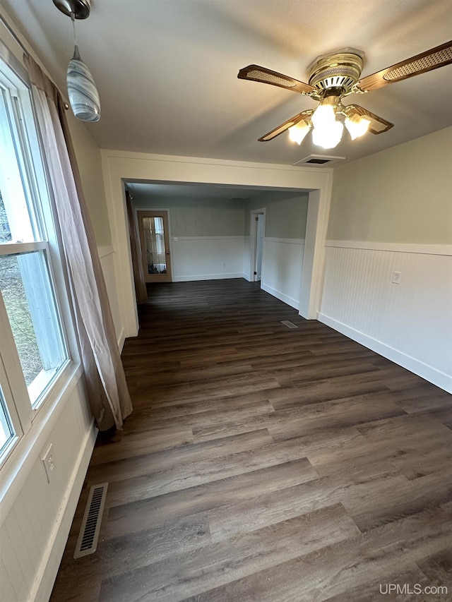 interior space featuring a wainscoted wall, visible vents, and dark wood finished floors