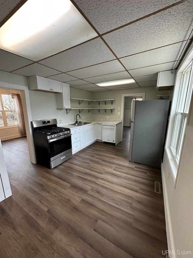 kitchen featuring a sink, stainless steel appliances, a paneled ceiling, white cabinets, and light countertops